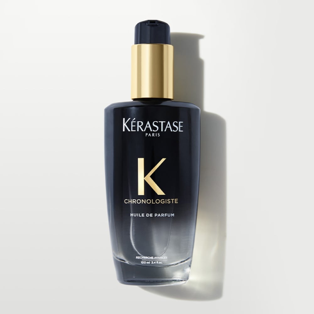 Chronologiste Huile de parfum hair oil is displayed on a pure grey background. The oil features an artful blend of addictive fragrances while providing hair shine and nourishment.